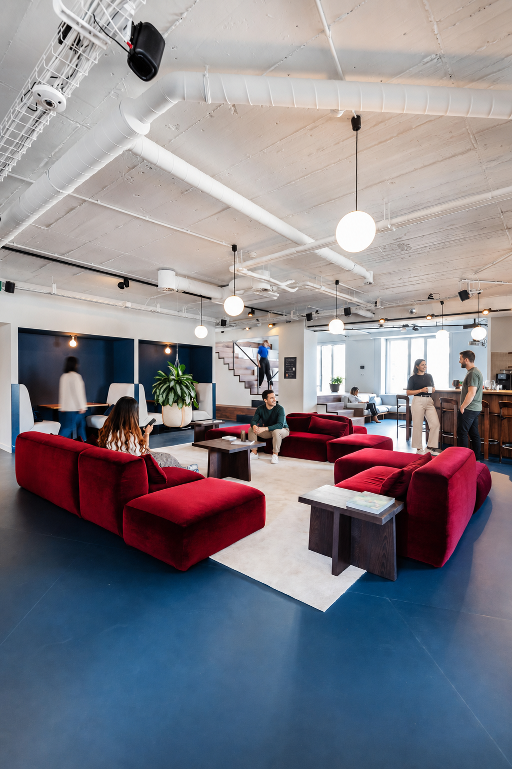 Bright Silversquare lounge with red sofas and coworkers