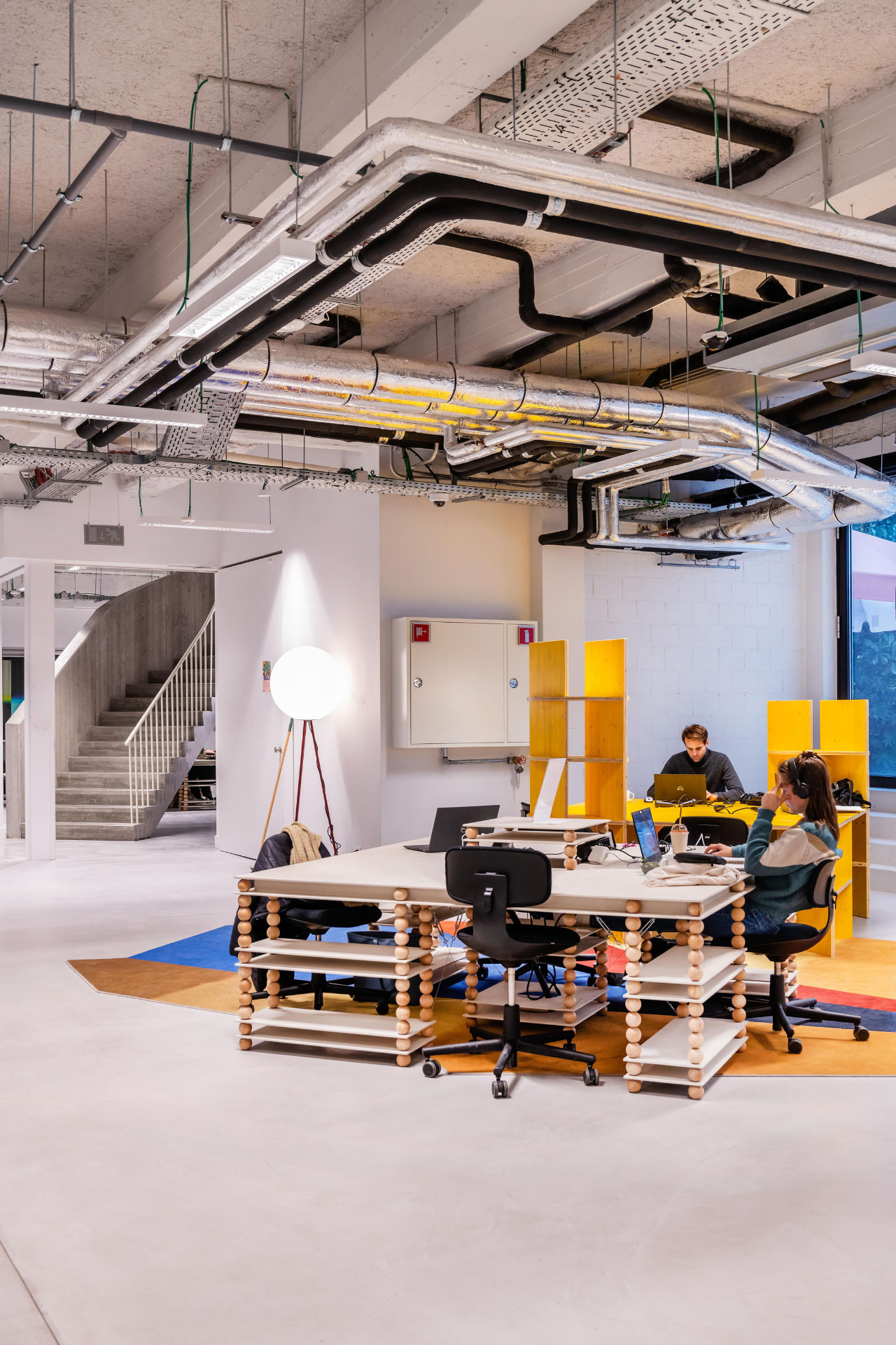 Open coworking floor with colourful furniture and geometric rug